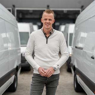 Autodealer staat tussen bedrijfswagens 